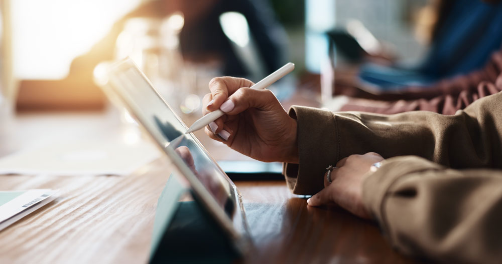 Woman working on a tablet with a stylus pen